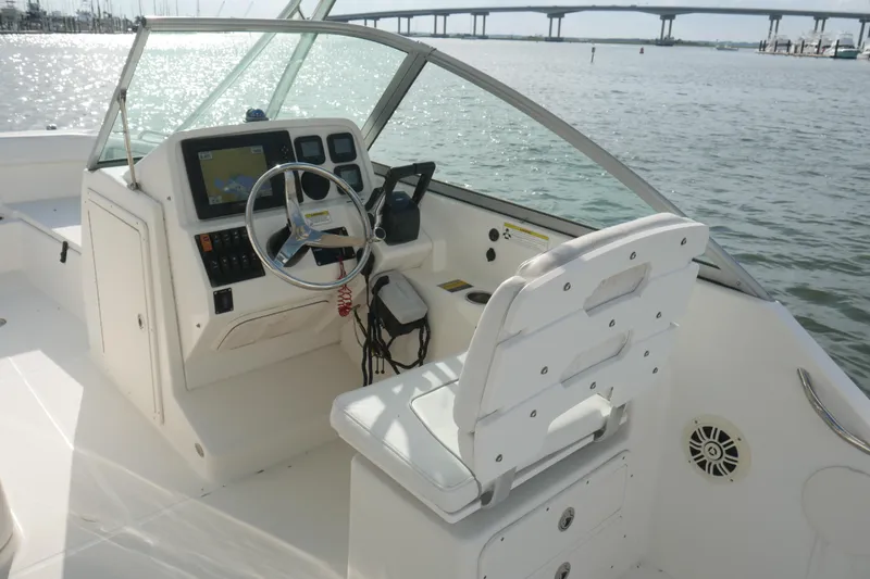 Slide: The Image of 2014 Carolina Cat 23DC boat cockpit with steering wheel and navigation system. - 16