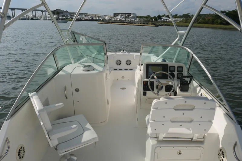 Slide: The Image of 2014 Carolina Cat 23DC boat interior with steering console and seating on calm water. - 19