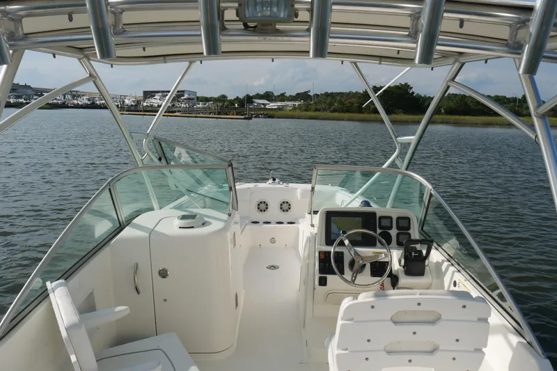 Slide: The Image of Interior view of 2014 Carolina Cat 23DC boat with steering console on calm water. - 20