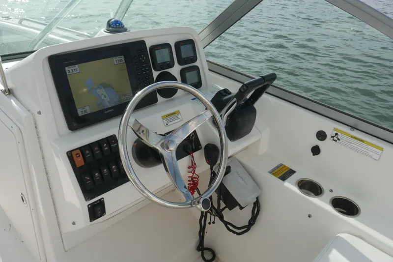 Slide: The Image of 2014 Carolina Cat 23DC boat dashboard with steering wheel and navigation system. - 25