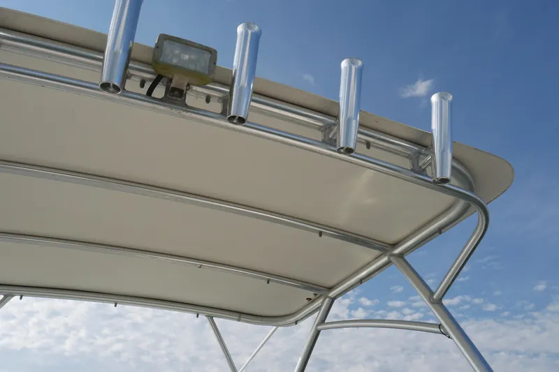 Slide: The Image of 2014 Carolina Cat 23DC boat top with rod holders against blue sky. - 29