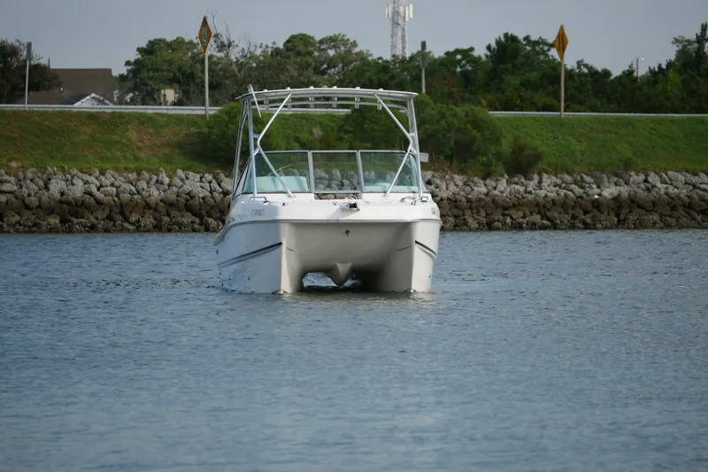 Slide: The Image of 2014 Carolina Cat 23DC boat cruising on a calm waterway. - 4