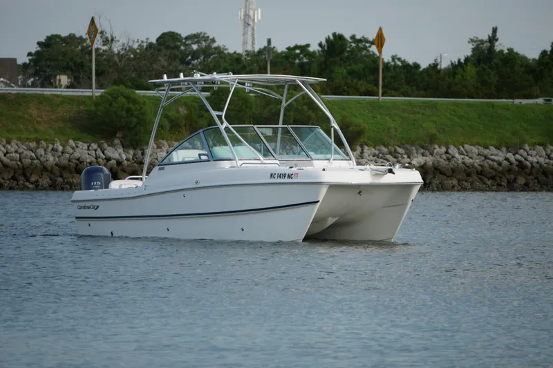 Slide: The Image of 2014 Carolina Cat 23DC boat cruising on a calm waterway. - 6