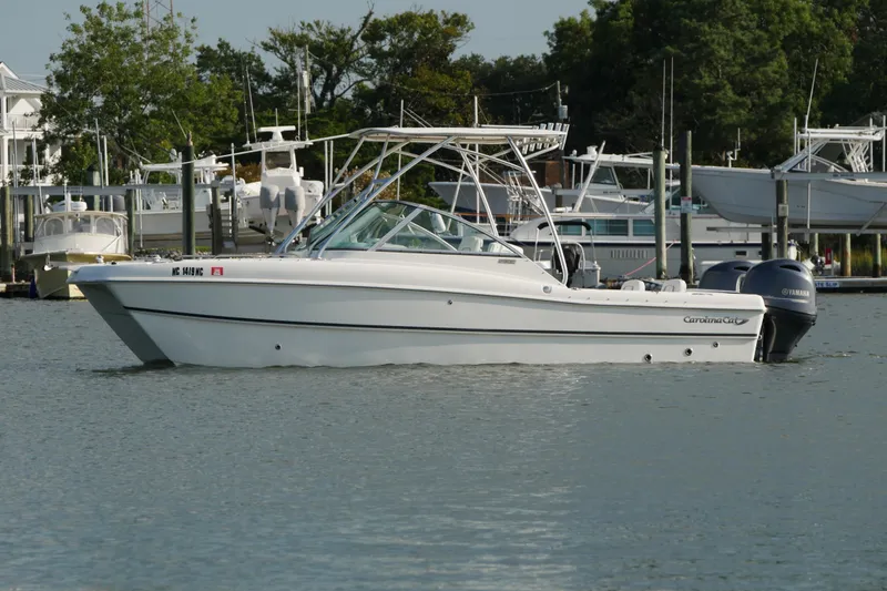 Slide: The Image of 2014 Carolina Cat 23DC boat docked in a marina, featuring dual Yamaha engines. - 7