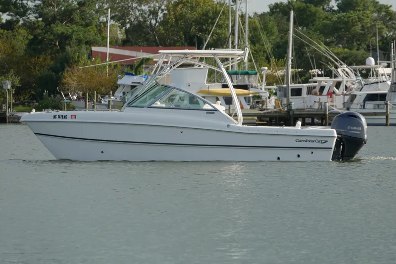Slide: The Image of 2014 Carolina Cat 23DC boat on water, with Yamaha outboard motor, docked marina background. - 8