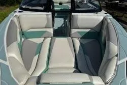 Slide: The Image of 2021 Centurion Ri245 boat interior with stylish, cushioned seating in teal and gray tones. - 10