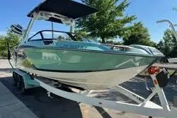 Slide: The Image of 2021 Centurion Ri245 boat on trailer, parked outdoors under clear blue sky. - 4