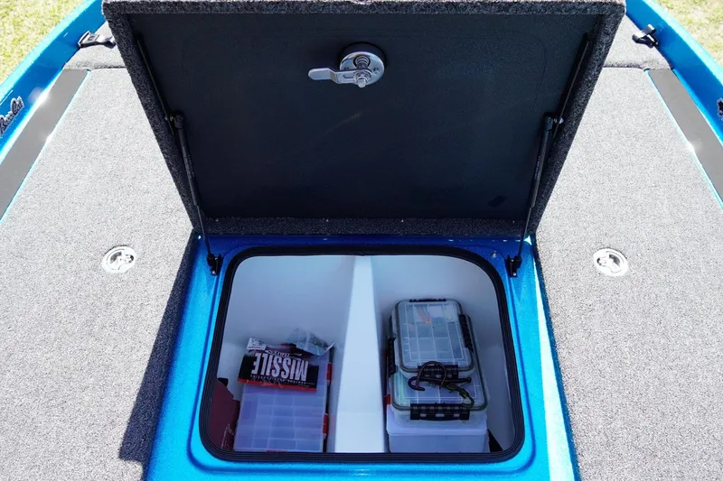 Slide: The Image of 2025 Bass Cat Puma STS storage compartment with organized fishing gear and tackle boxes. - 17