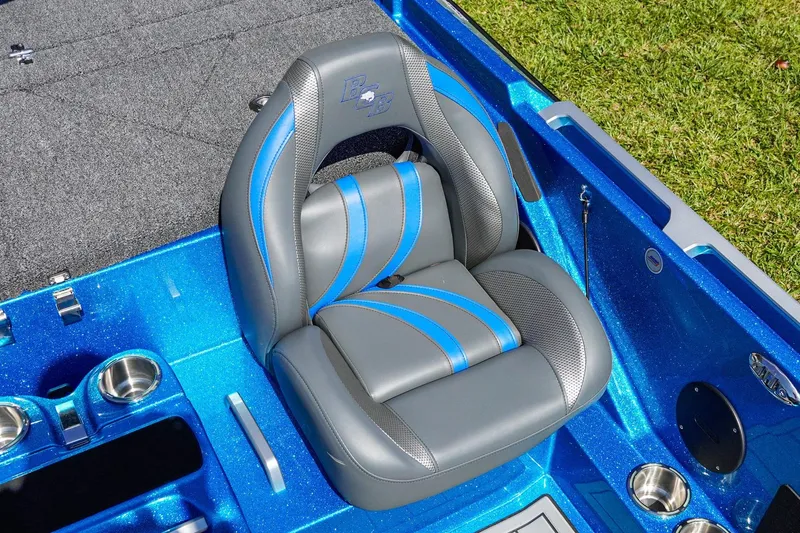 Slide: The Image of 2025 Bass Cat Puma STS boat seat with blue and gray design, cup holders, and carpeted flooring. - 20