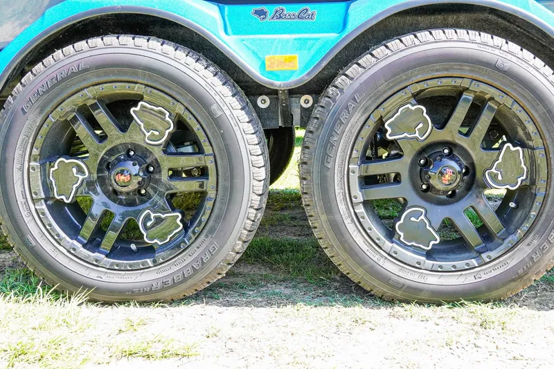 Slide: The Image of 2025 Bass Cat Puma STS wheels with custom black rims and General tires. - 25