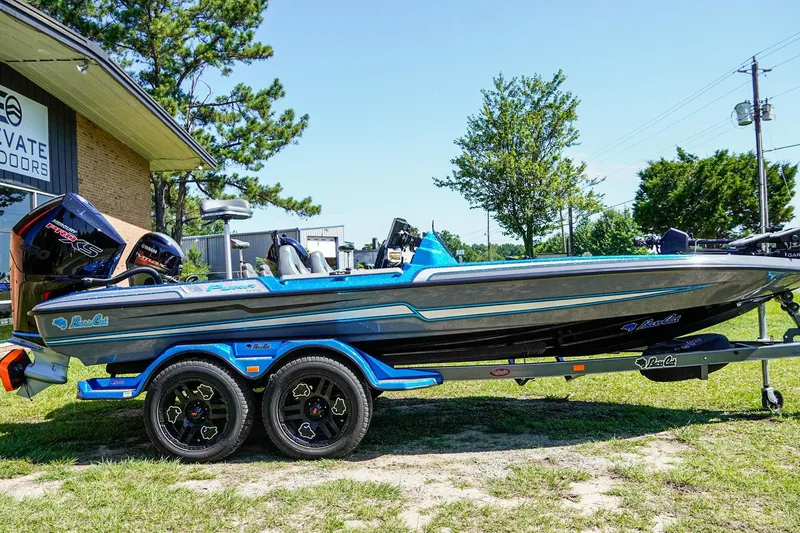 Slide: The Image of 2025 Bass Cat Puma STS boat on trailer, parked outdoors near building. - 4