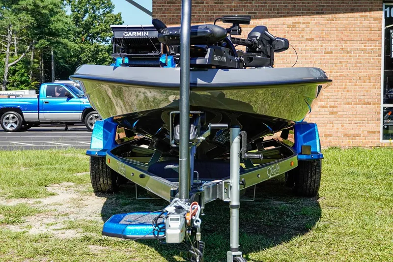 Slide: The Image of 2025 Bass Cat Puma STS boat on trailer, featuring Garmin equipment, parked outdoors. - 48
