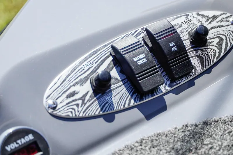 Slide: The Image of Control panel of 2025 Bass Cat Puma STS boat with trim and battery check switches. - 53