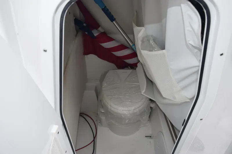 Slide: The Image of Interior of 2025 Sea Hunt Ultra 245 SE boat with compact toilet and storage. - 13