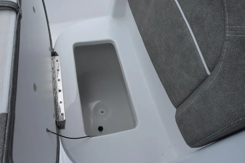 Slide: The Image of Storage compartment in 2025 Sea Hunt Ultra 245 SE boat, featuring gray upholstery. - 15
