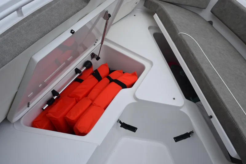 Slide: The Image of Storage compartment on 2025 Sea Hunt Ultra 245 SE with life jackets and equipment. - 16