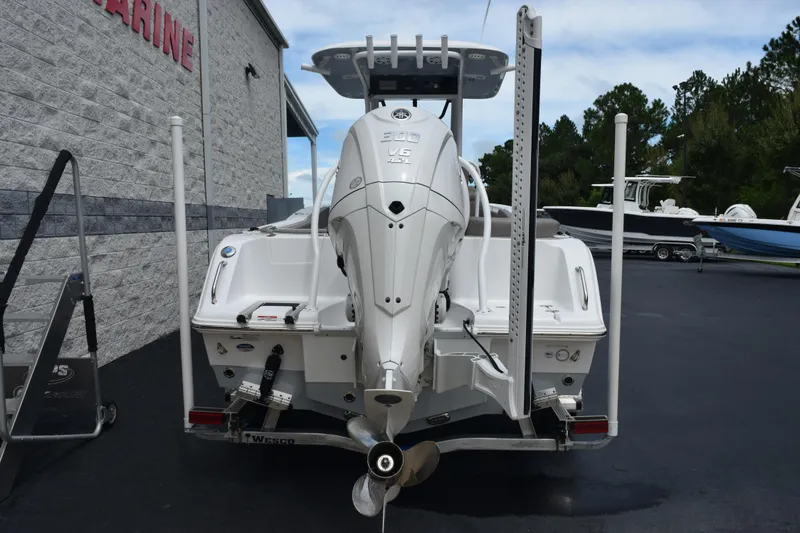 Slide: The Image of 2025 Sea Hunt Ultra 245 SE boat with powerful outboard motor, parked at a marine dealership. - 5