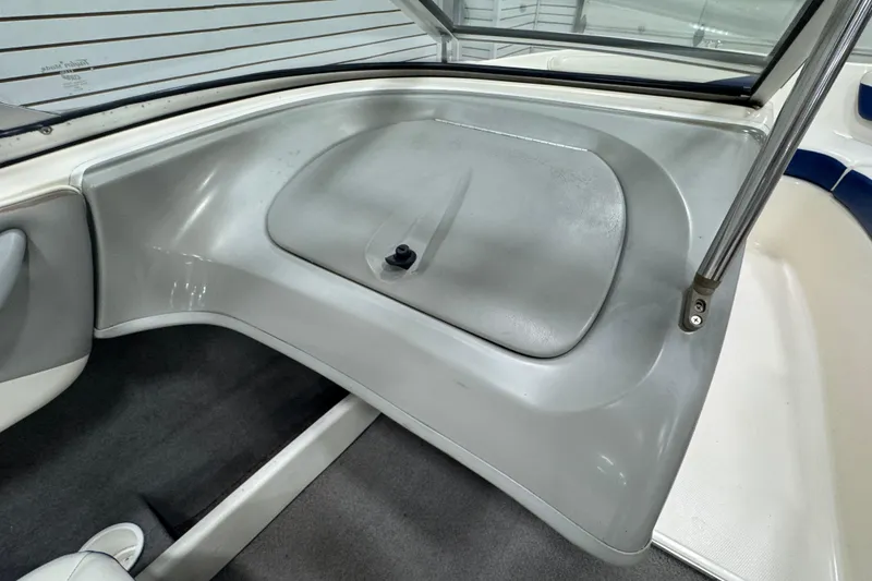 Slide: The Image of 2005 Bayliner 205 BR boat interior with storage compartment and seating area. - 13