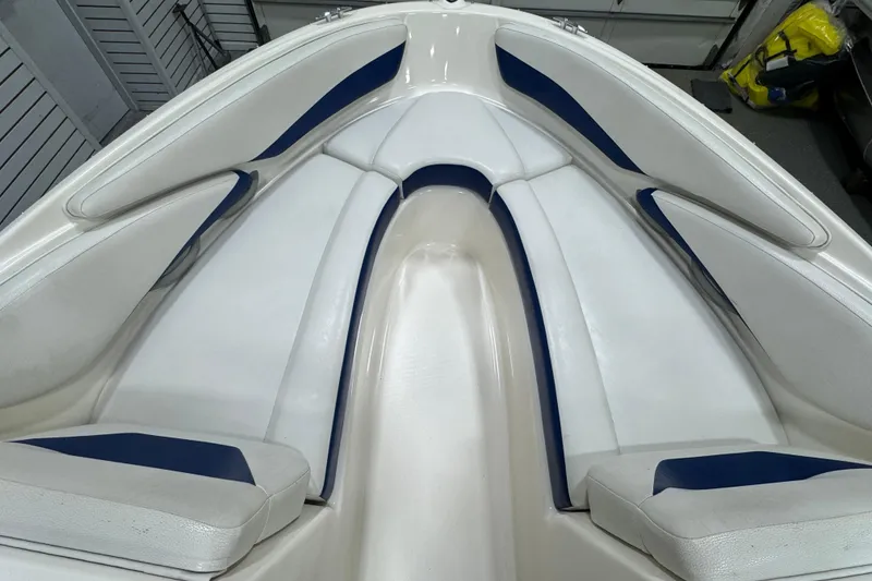 Slide: The Image of Interior view of a 2005 Bayliner 205 BR boat with white and blue seating. - 17