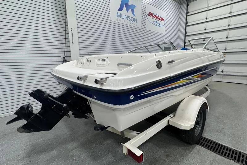 Slide: The Image of 2005 Bayliner 205 BR boat on trailer in showroom, Munson Surf & Wake signage. - 3