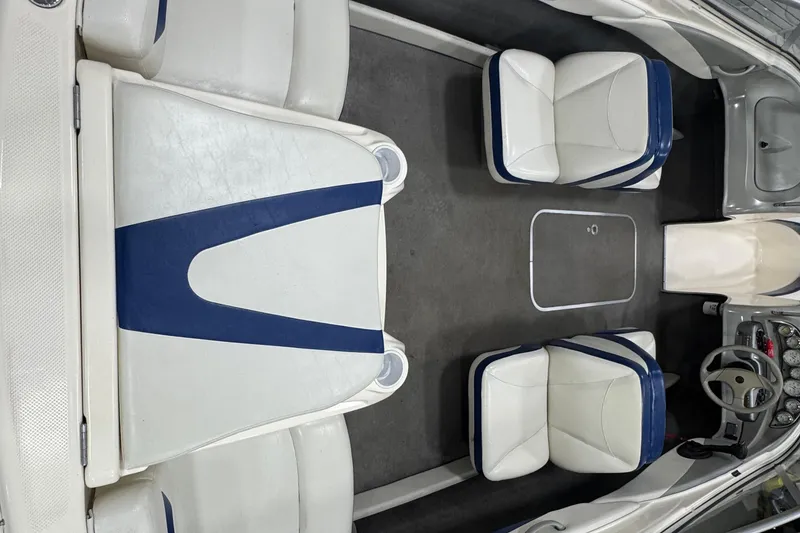 Slide: The Image of 2005 Bayliner 205 BR boat interior with white and blue seating, steering wheel, and dashboard. - 6