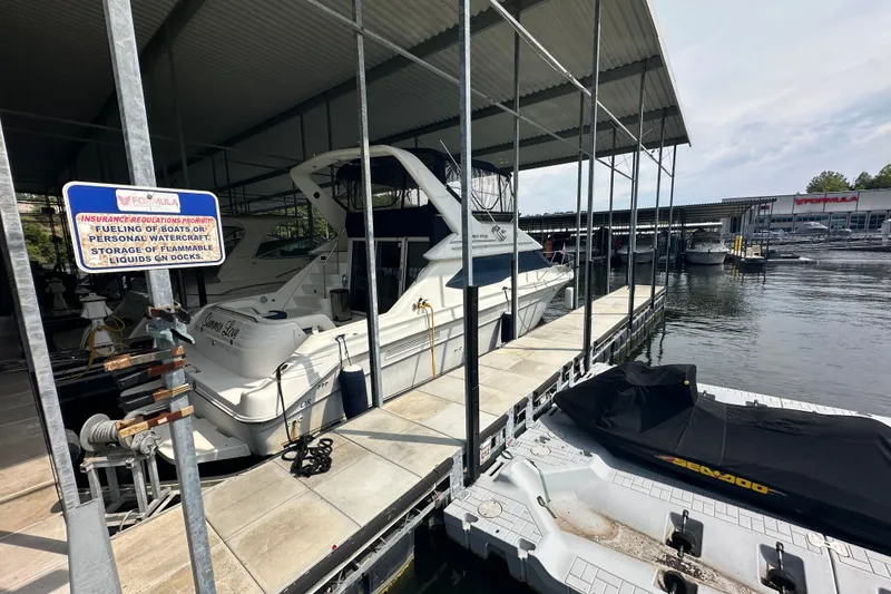Slide: The Image of 1995 Sea Ray 440 Express Bridge docked at marina under covered slip. - 11