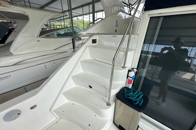 Slide: The Image of 1995 Sea Ray 440 Express Bridge yacht with stairs and safety equipment in marina. - 16