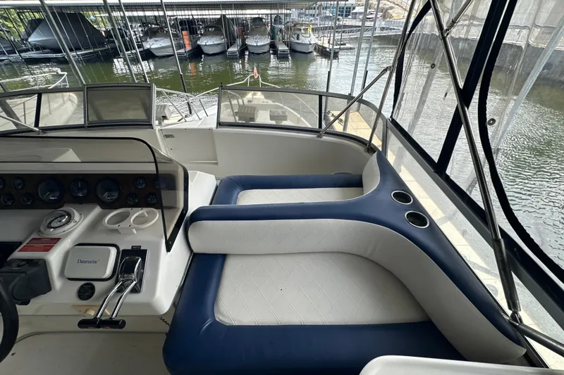 Slide: The Image of 1995 Sea Ray 440 Express Bridge cockpit with blue and white seating, docked at marina. - 20