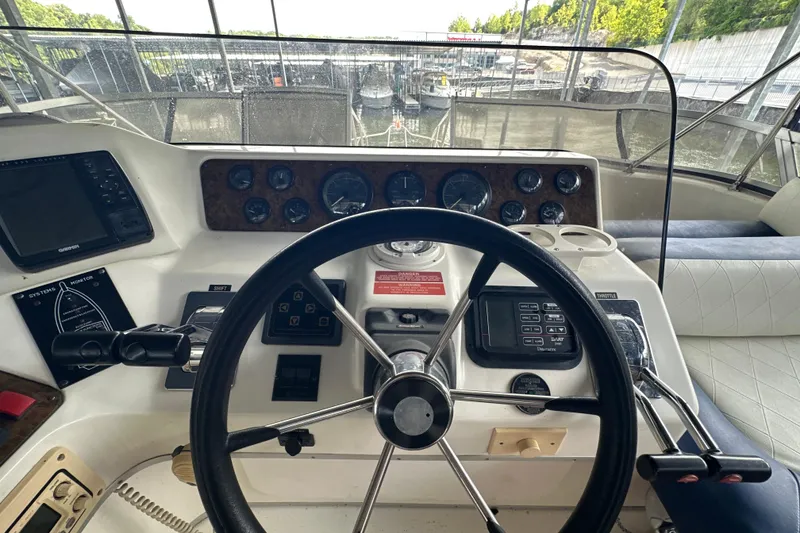 Slide: The Image of 1995 Sea Ray 440 Express Bridge helm with steering wheel and control panel. - 22