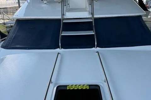 Slide: The Image of 1995 Sea Ray 440 Express Bridge yacht with covered windows and sleek design. - 28