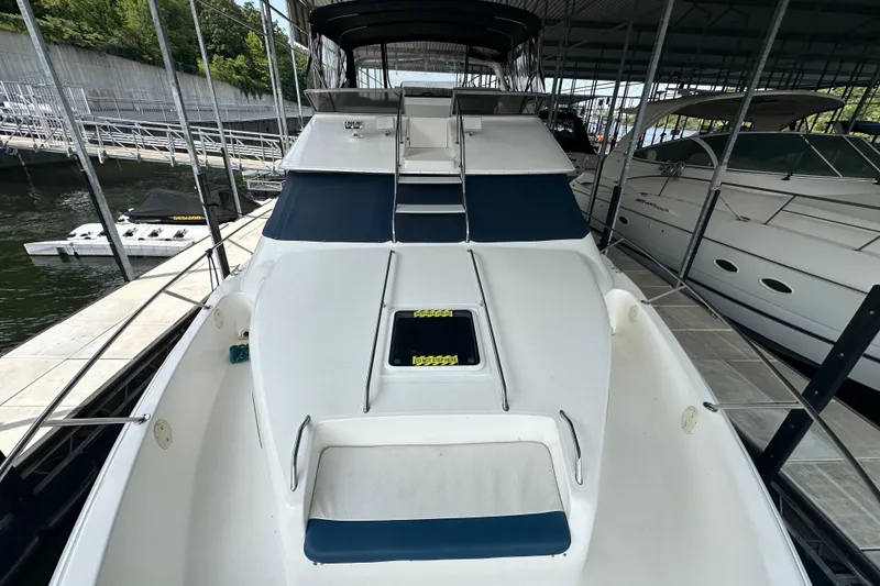 Slide: The Image of 1995 Sea Ray 440 Express Bridge yacht docked in a marina, front view. - 30