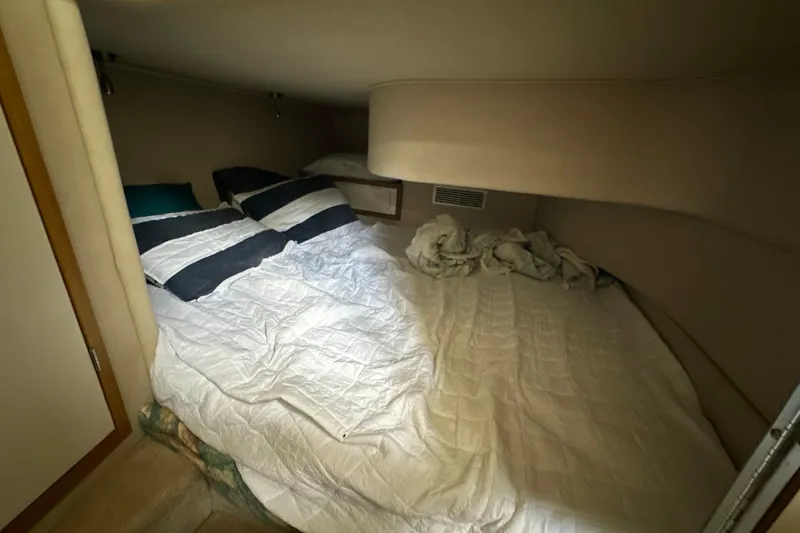 Slide: The Image of Cozy cabin interior of 1995 Sea Ray 440 Express Bridge with bed and pillows. - 34