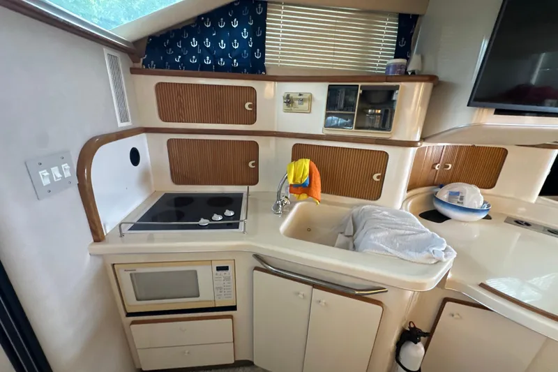 Slide: The Image of Interior of 1995 Sea Ray 440 Express Bridge yacht kitchen with stove, microwave, and sink. - 35
