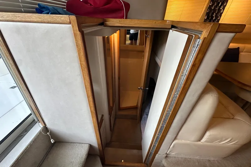 Slide: The Image of Interior stairs of 1995 Sea Ray 440 Express Bridge yacht, featuring wood and carpet design. - 37