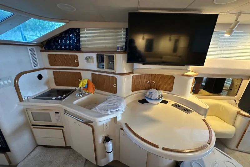 Slide: The Image of Interior of 1995 Sea Ray 440 Express Bridge yacht with modern kitchen and TV. - 41