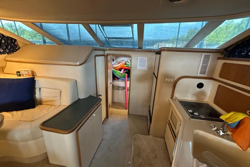 Slide: The Image of Interior of 1995 Sea Ray 440 Express Bridge with seating, kitchenette, and storage. - 42