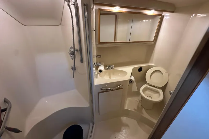 Slide: The Image of Bathroom interior of 1995 Sea Ray 440 Express Bridge yacht, featuring shower and toilet. - 43