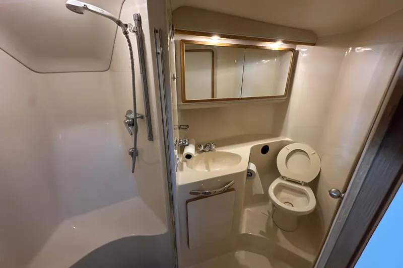 Slide: The Image of Bathroom interior of 1995 Sea Ray 440 Express Bridge yacht, featuring shower, sink, and toilet. - 44