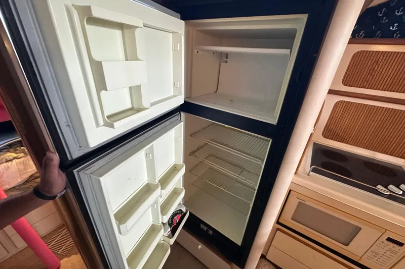 Slide: The Image of 1995 Sea Ray 440 Express Bridge interior fridge and kitchen area. - 47