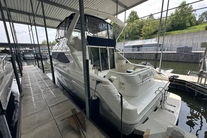 Slide: The Image of 1995 Sea Ray 440 Express Bridge docked in a covered marina. - 8