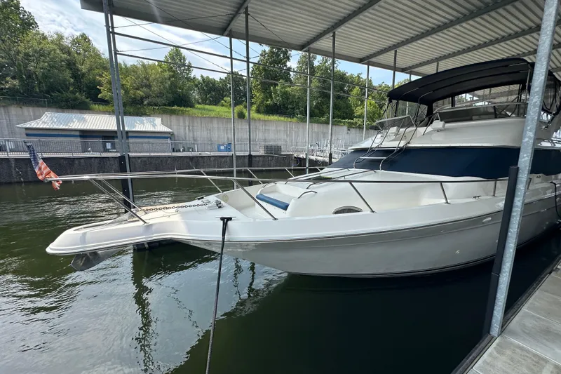 Slide: The Image of 1995 Sea Ray 440 Express Bridge yacht docked under a covered marina. - 9