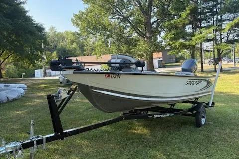 The Image of 2019 Starcraft Patriot boat on trailer, parked on grass, surrounded by trees. - 1