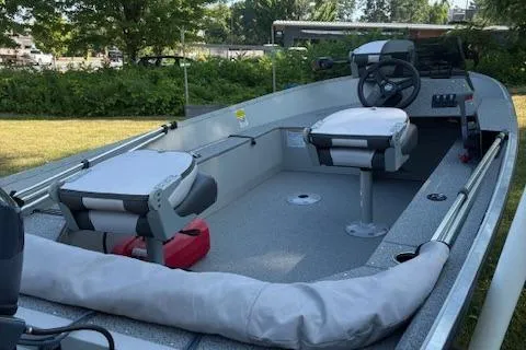 Slide: The Image of 2019 Starcraft Patriot boat with seating and steering wheel, parked outdoors. - 4