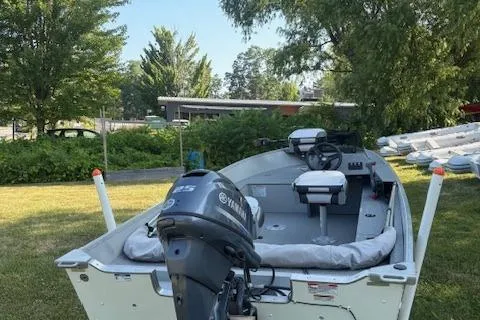 Slide: The Image of 2019 Starcraft Patriot boat with Yamaha motor, parked on grass near trees. - 5