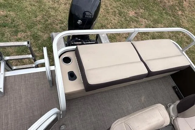 Slide: The Image of 2018 Sun Tracker SportFish 22 XP3 pontoon boat with cushioned seating and outboard motor. - 10