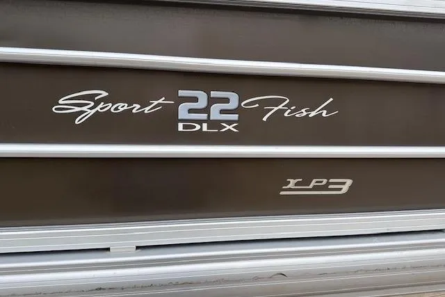 Slide: The Image of 2018 Sun Tracker SportFish 22 XP3 boat logo on metallic surface. - 18