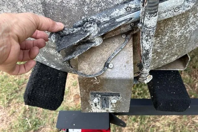 Slide: The Image of 2018 Sun Tracker SportFish 22 XP3 boat with worn propeller and hand inspecting damage. - 35