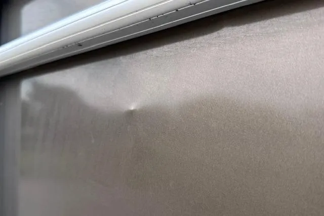 Slide: The Image of Close-up of a dent on a 2018 Sun Tracker SportFish 22 XP3 boat exterior. - 36