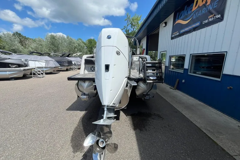 Slide: The Image of 2025 Avalon Excalibur Versatile boat at Lake Dora Marine dealership, rear view. - 3
