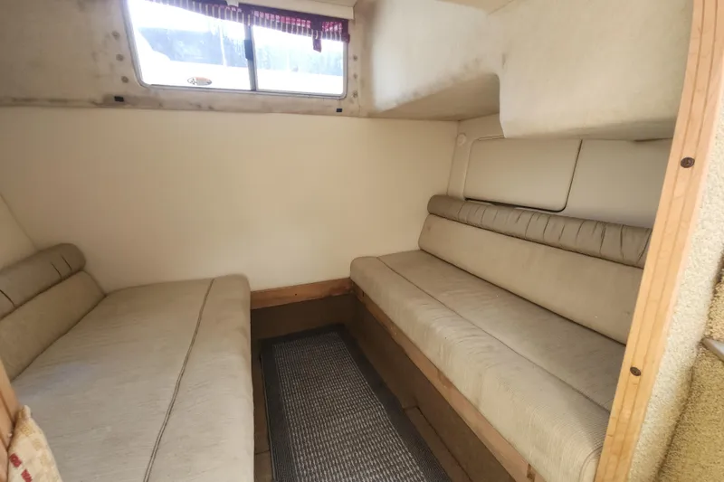 Slide: The Image of Interior cabin of 2000 Maxum 3300 SCR boat with beige seating and window. - 13